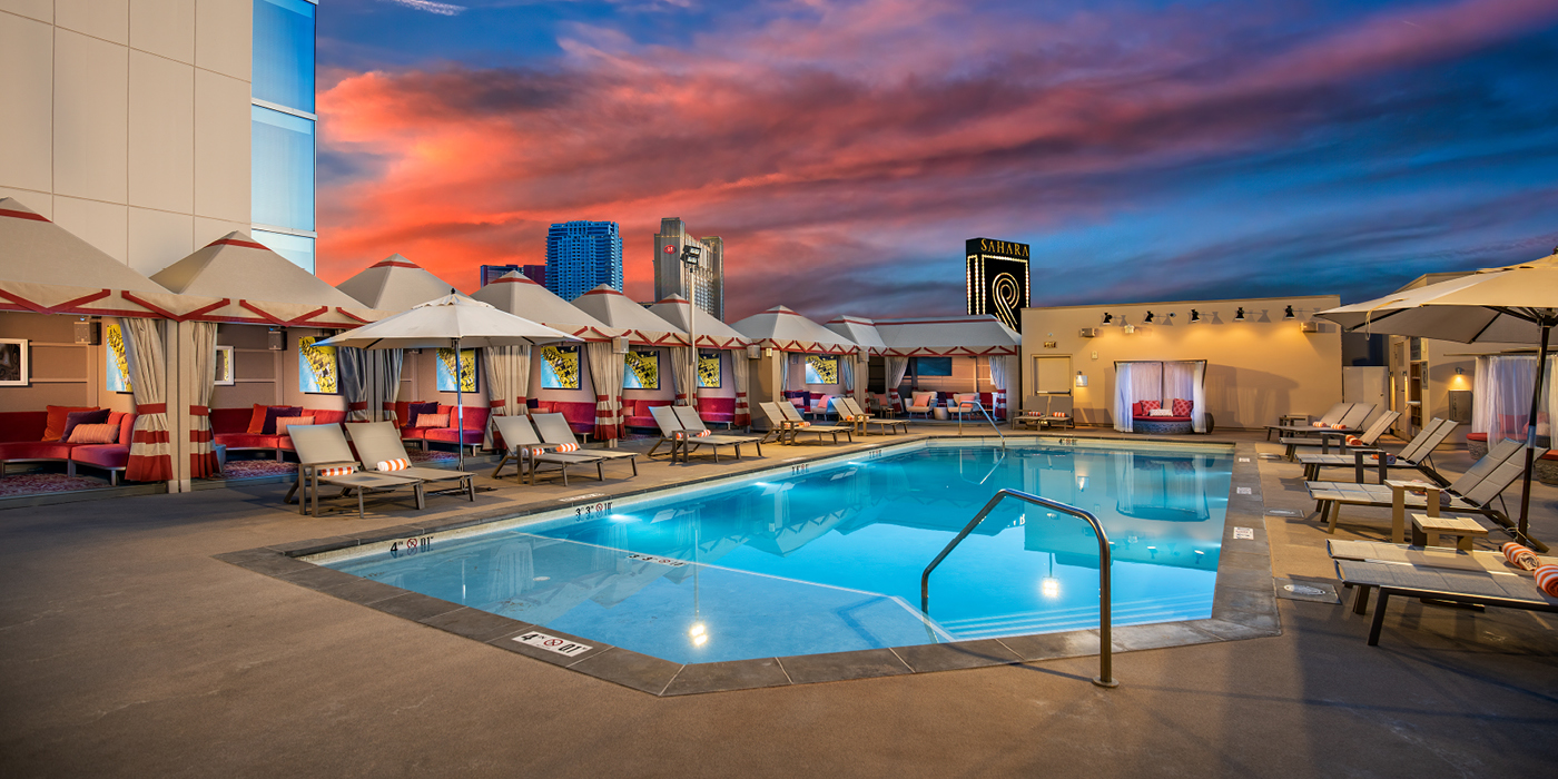 Alexandria pool photo at dusk with lounge chairs and cabanas