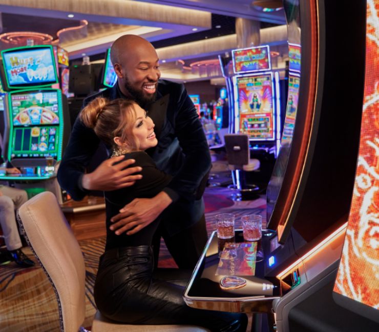 two people playing slot machines