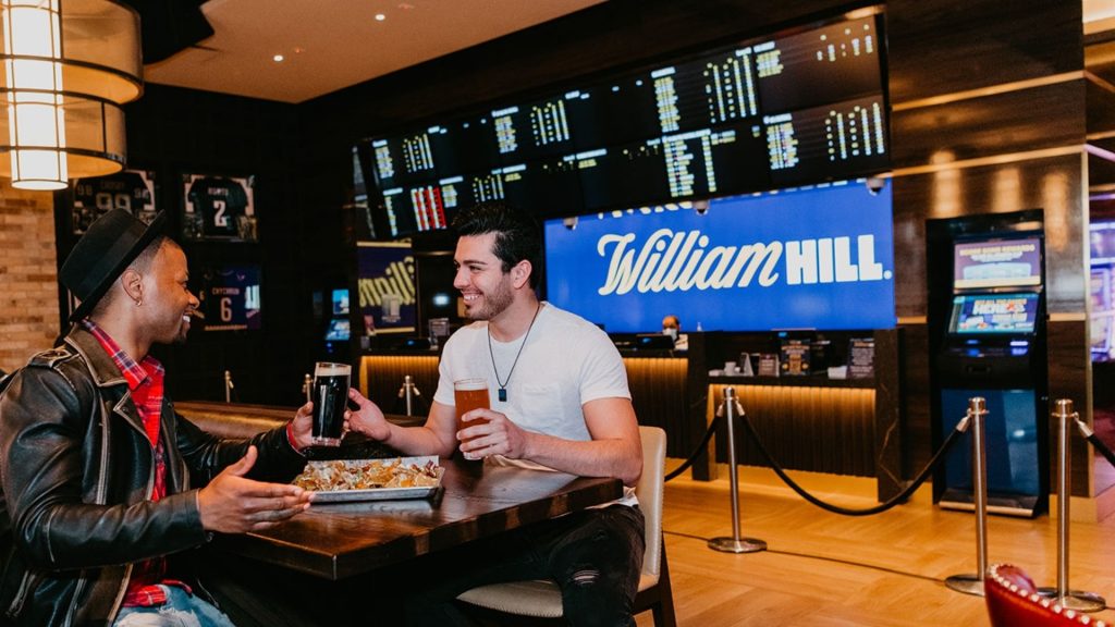 William Hill lifestyle shot with two guys drinking beer and laughing