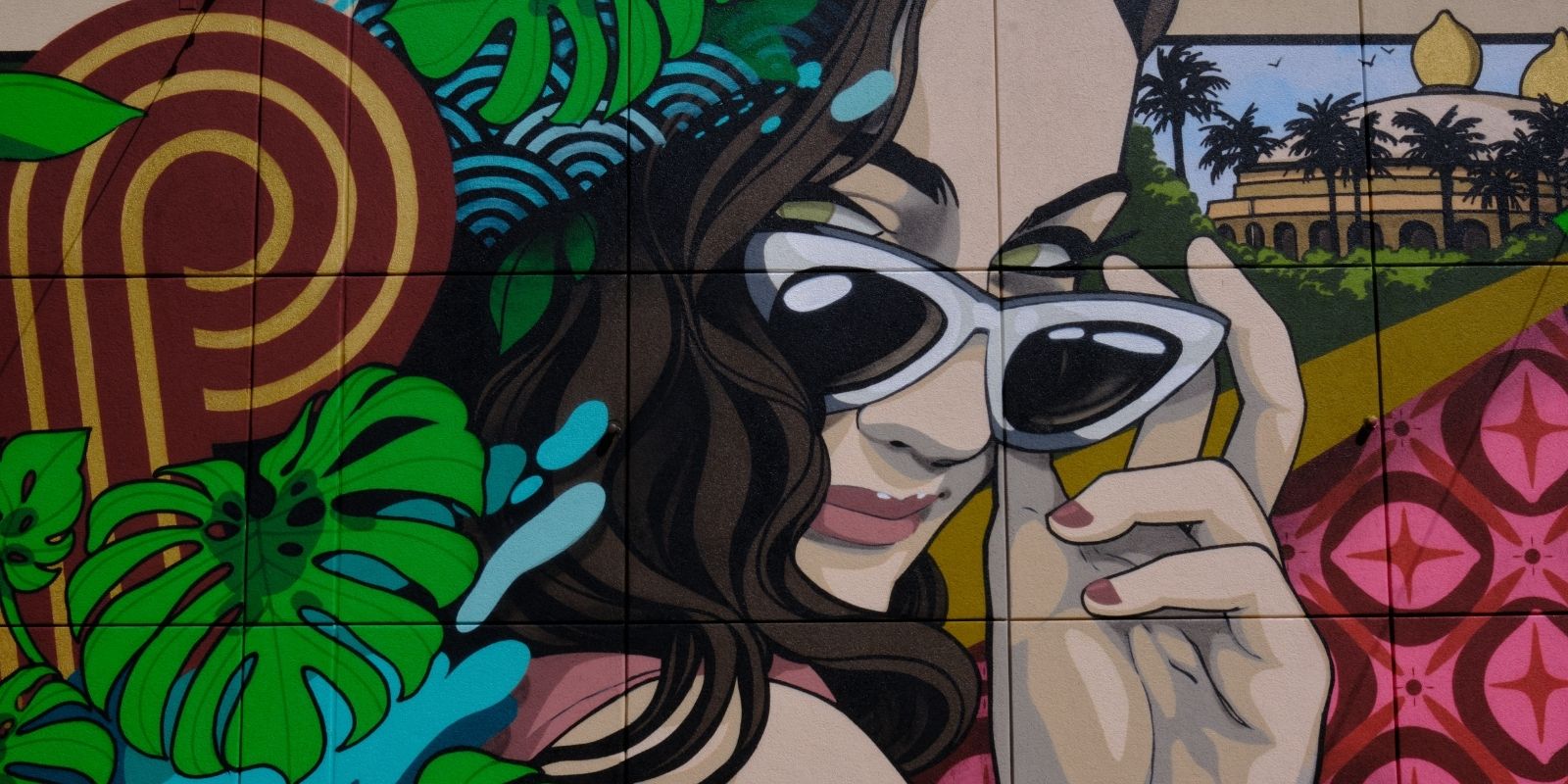 Mural art at the Retro Pool in SAHARA. Includes a woman peeking out above her sunglasses, leaves and the infinity S