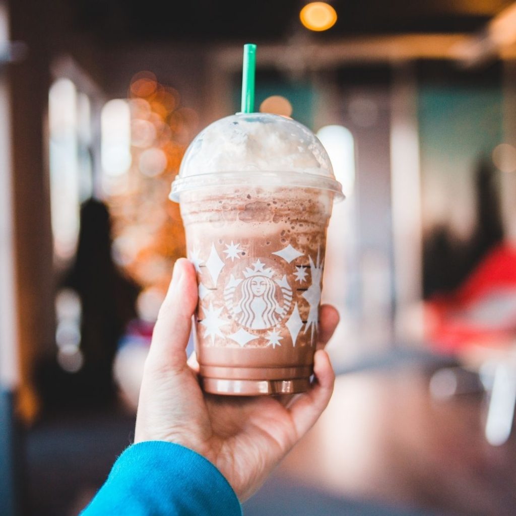 Someone holding up a Starbucks frappaccino