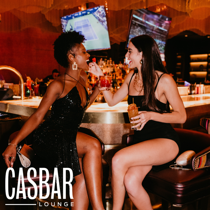 Two girls flirting with each other at CASBAR Lounge with drinks