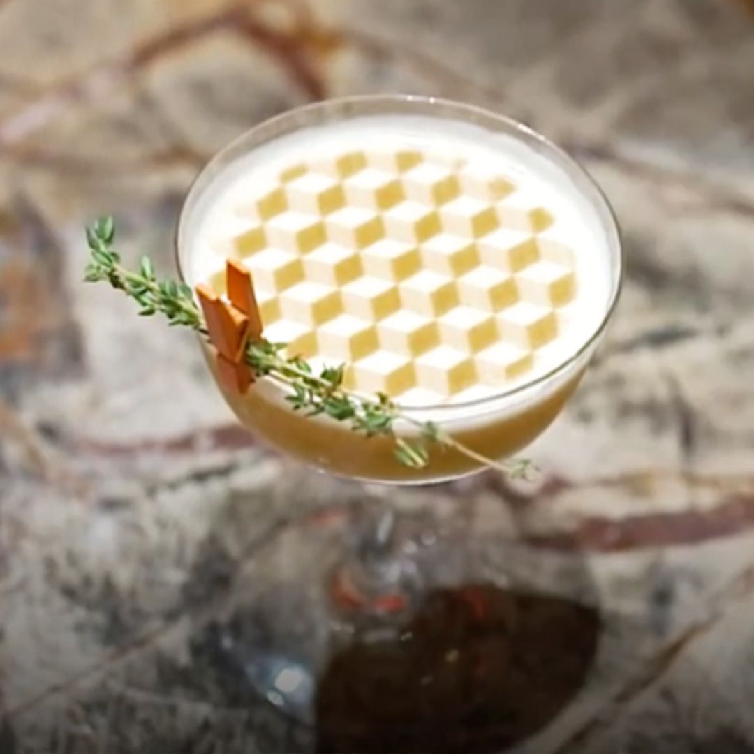 Two cocktails sitting on a table with text floating on the top of the drinks. One says Love Wins and shows a rainbow and the other says equality