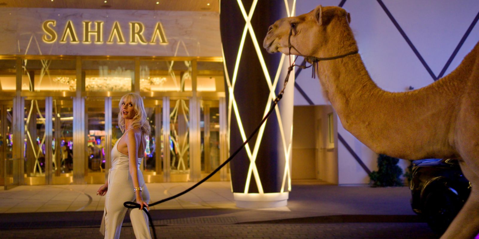 Woman and camel walking in front of the SAHARA building