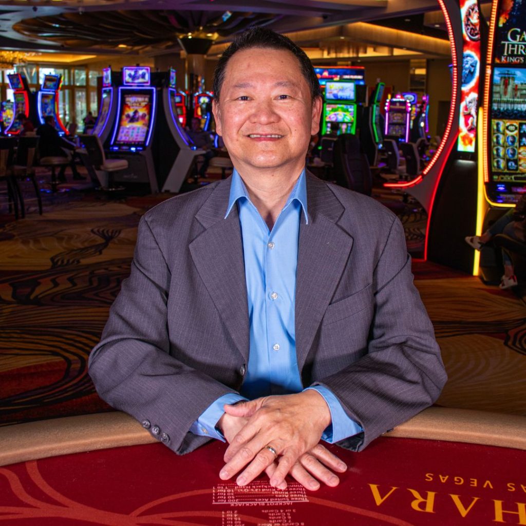 Casino host sitting at table posing for picture