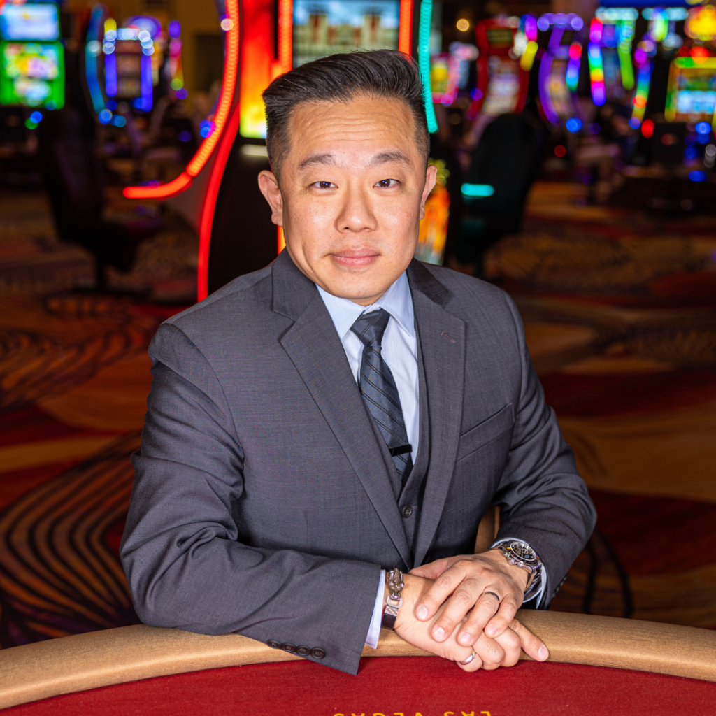 Casino host sitting at table posing for picture