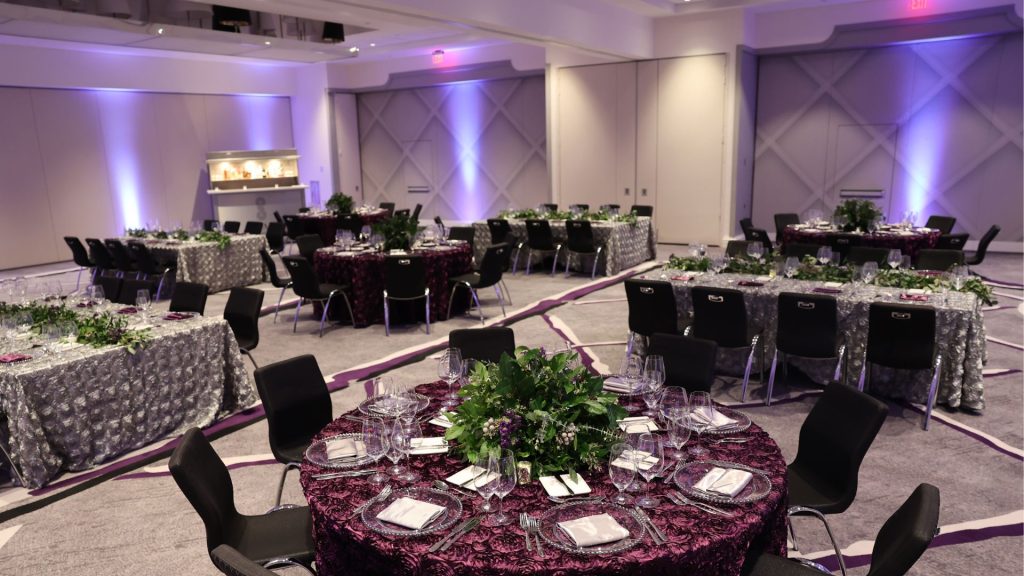 Catering and banquets set up within a meeting space showing floral arrangements and table settings.