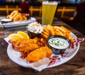 Fish and Chip fridays at Chickie's & Pete's featuring a side of fries, lemon wedge, homemade tartar sauce, and coleslaw.